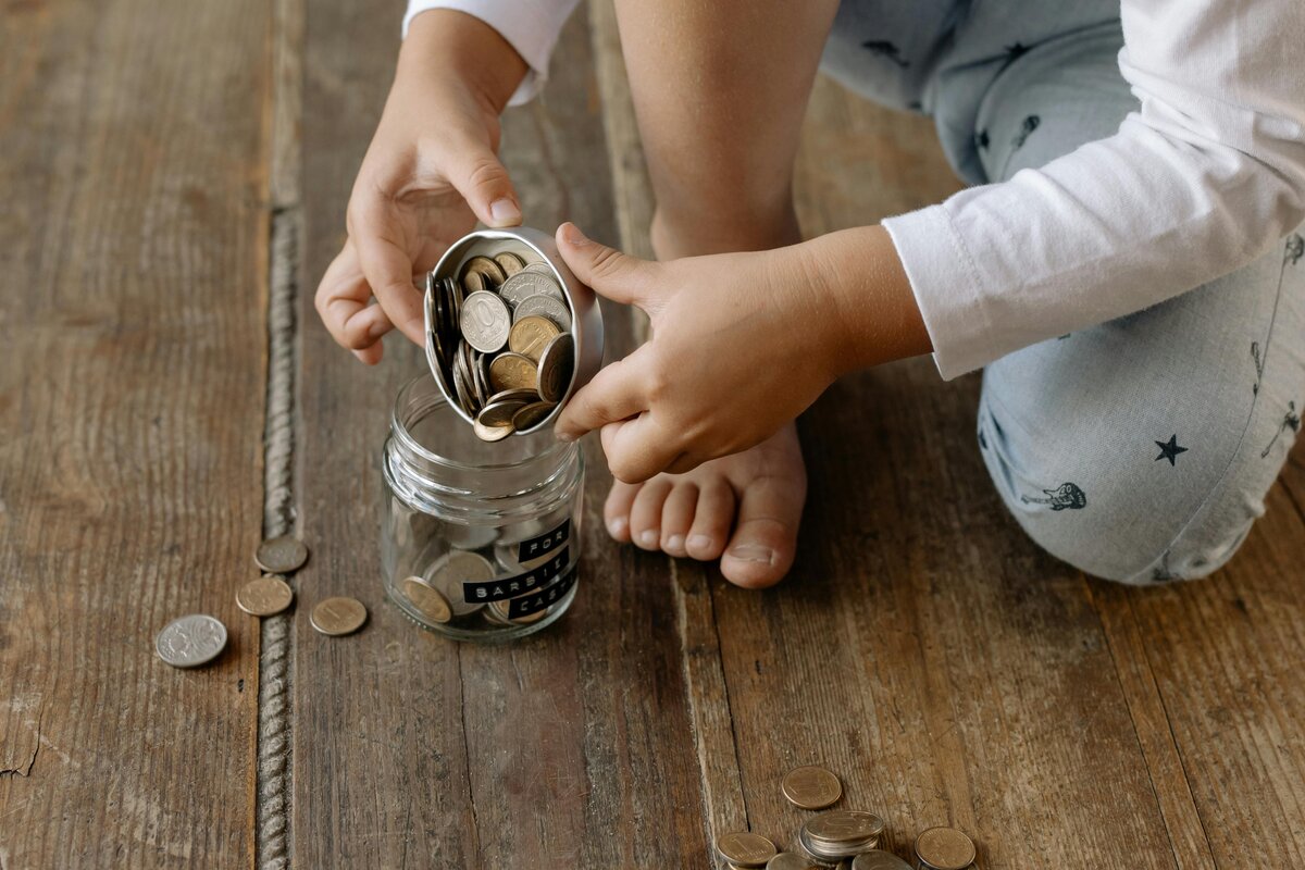 Child accumulating coins in a savings pot - financial planning and saving habits concept